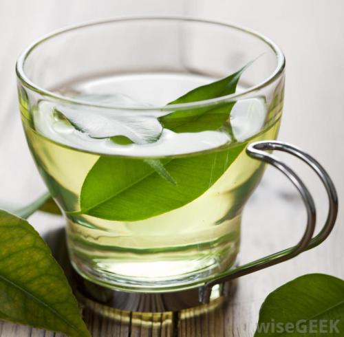 cup-of-green-tea-with-leaves-on-wood